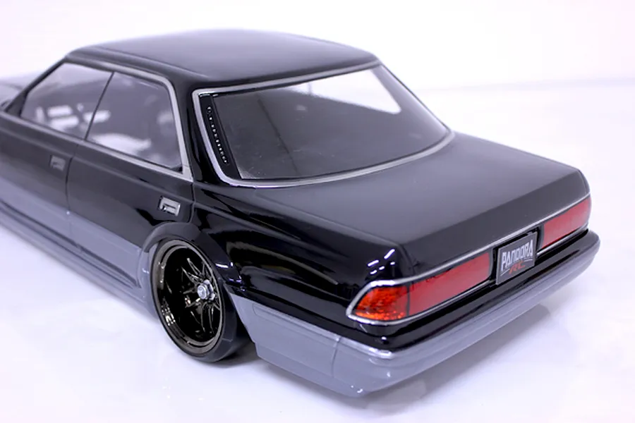 Rear three-quarter studio view of a black and silver RC drift car body shell with detailed tail lights and custom wheels.