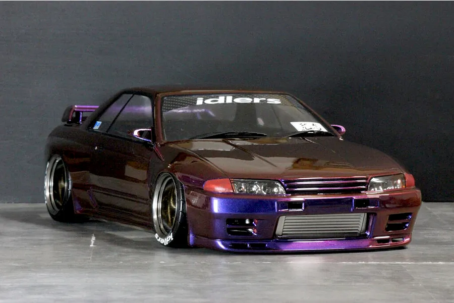 Custom painted purple and bronze gradient RC drift car body shell mounted on a chassis with dish wheels, styled like a Nissan Skyline GT-R R32.