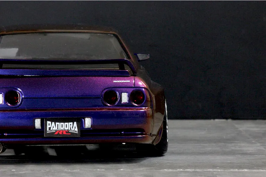 Rear view of a painted Pandora RC BNR32 Skyline GT-R drift body shell in metallic purple, featuring detailed taillights and a Pandora RC license plate.