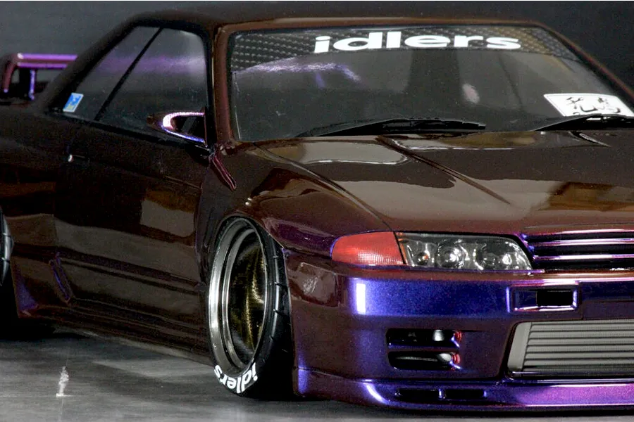 Close-up of a custom painted purple and brown Nissan Skyline GT-R RC drift car body shell with deep dish wheels.
