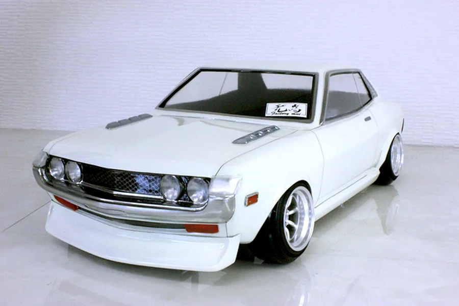 A painted white Pandora RC Toyota Celica 1600GT body shell mounted on an RC chassis against a white background.