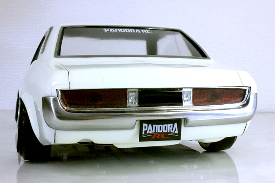 Rear view of the white Pandora RC Toyota Celica 1600GT body shell, showing taillights, chrome bumper, and Pandora RC license plate.