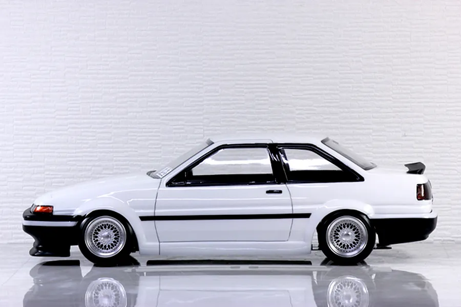Side profile view of a painted white and black Toyota AE86 Trueno 2-door RC body shell with mesh wheels.
