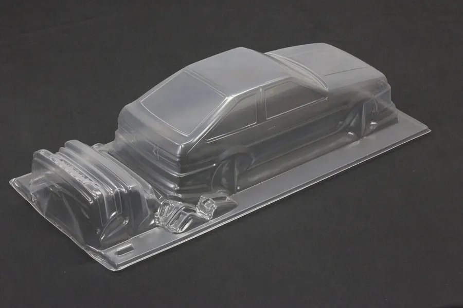 Unpainted clear polycarbonate RC car body shell for a Toyota AE86 Corolla Levin on a dark surface.