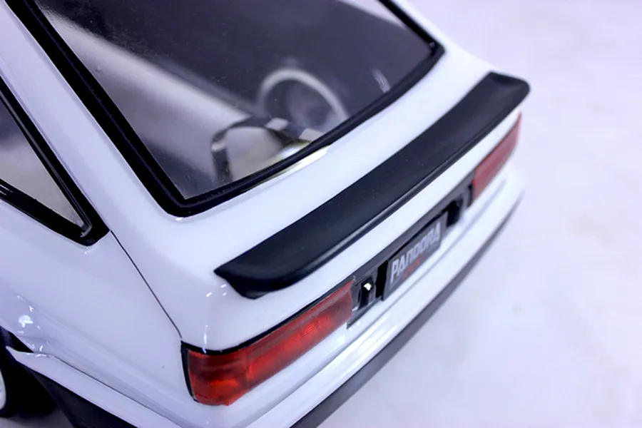 Close-up view of the rear end of a white RC drift car body showing the trunk spoiler, taillights, and rear window.