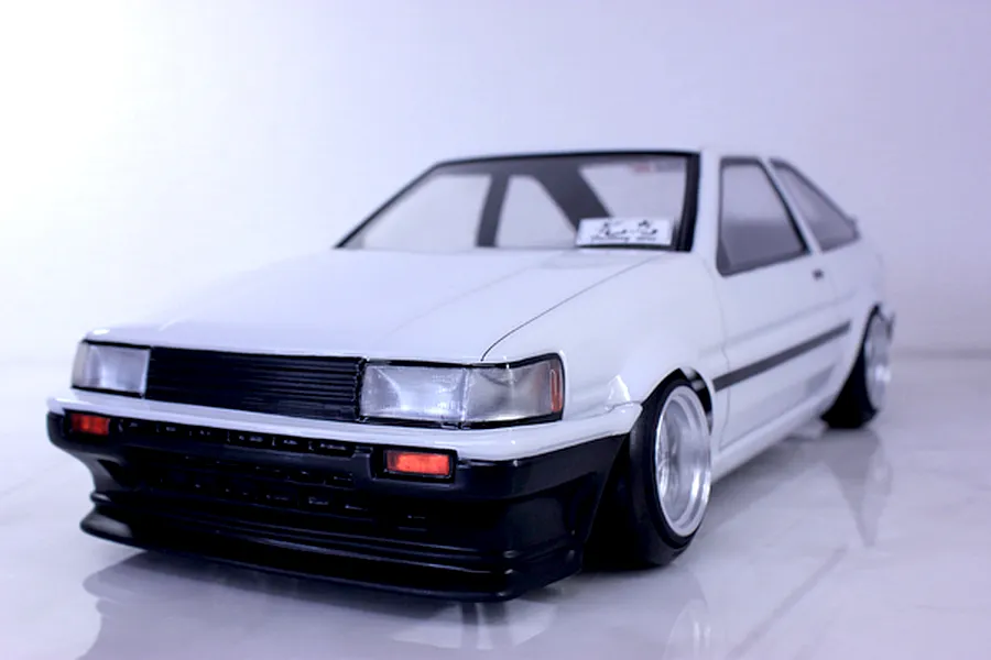 White Pandora RC Toyota AE86 Corolla Levin 3-door drift body shell on a reflective surface.