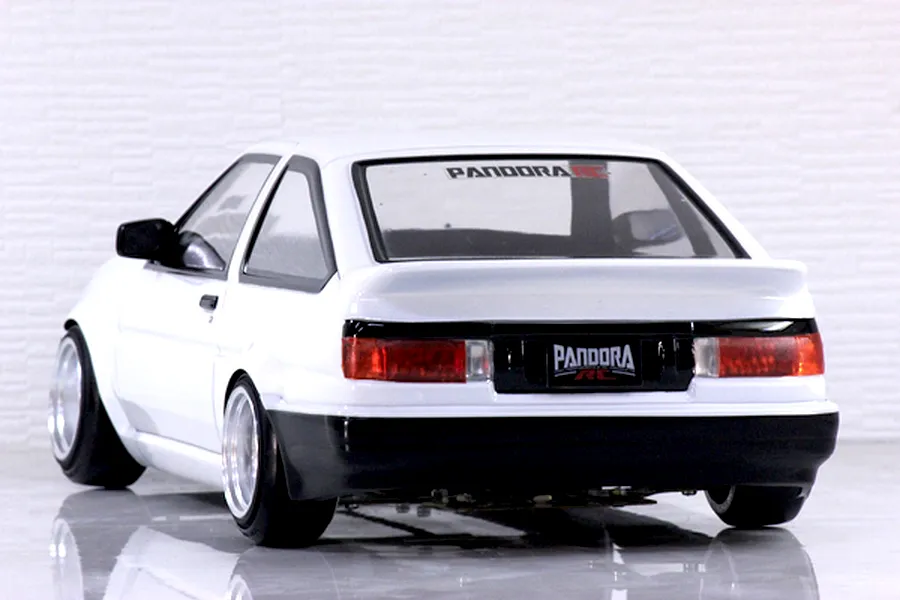 Rear three-quarter view of a white Pandora RC Toyota AE86 Sprinter Trueno drift body shell mounted on an RC chassis.