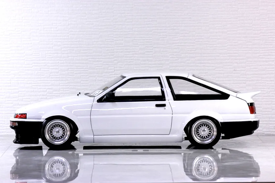 Side profile of a white Pandora RC Toyota AE86 Sprinter Trueno 3-door body shell mounted on an RC chassis with mesh wheels.