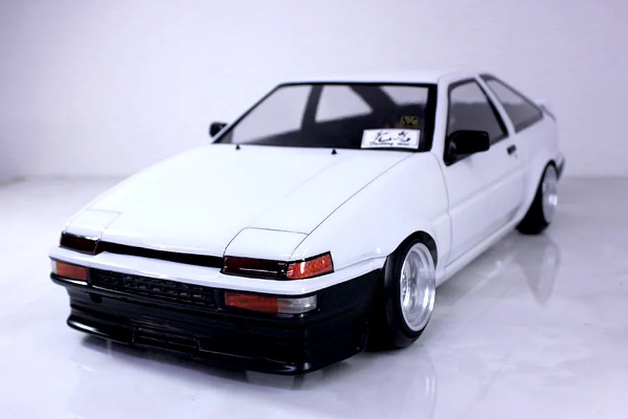 A painted white and black Pandora RC Toyota AE86 Sprinter Trueno 3-door body shell mounted on an RC chassis.