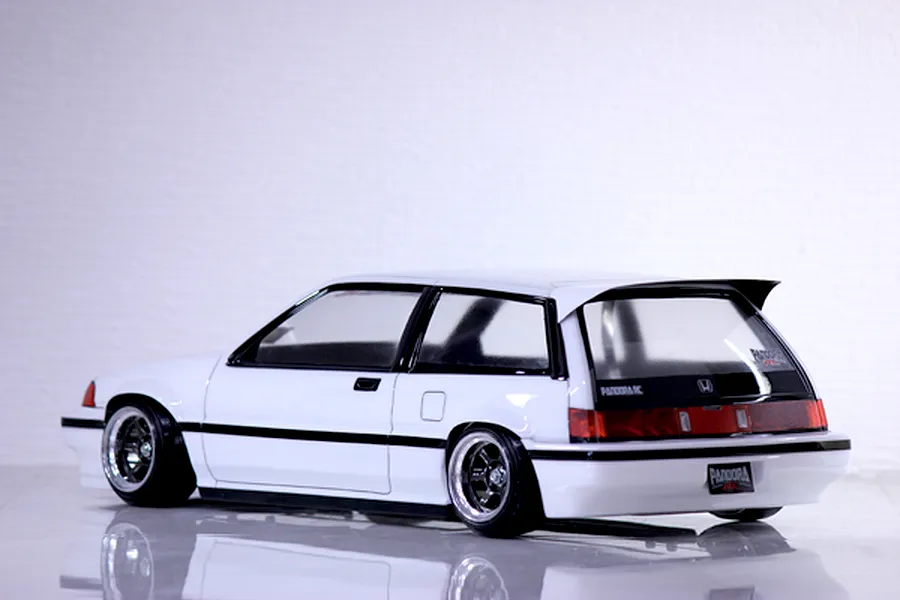 Rear three-quarter view of a painted white Honda Civic Si RC drift car body shell with black trim and custom wheels.