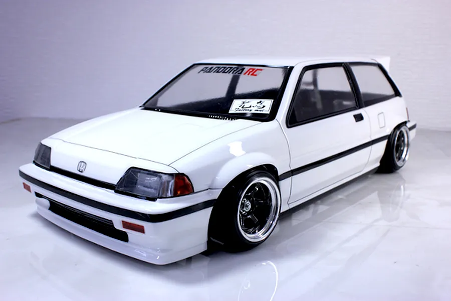 A painted white Honda Civic RC drift car body mounted on a chassis with black wheels against a white studio background.