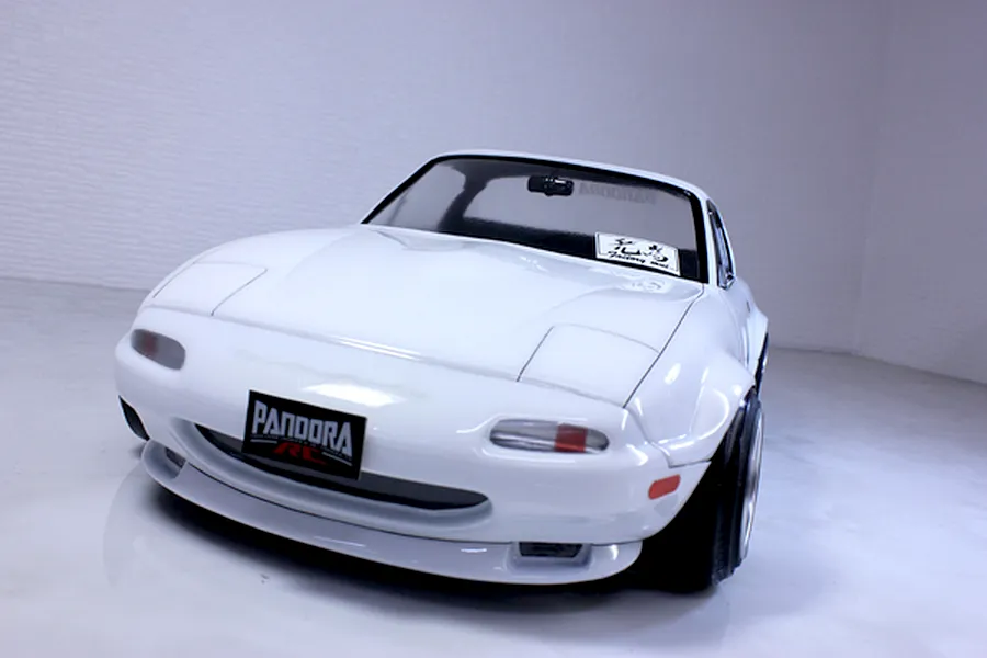 Front three-quarter view of a white Mazda Eunos Roadster NA RC drift car body shell with Pandora RC license plate.