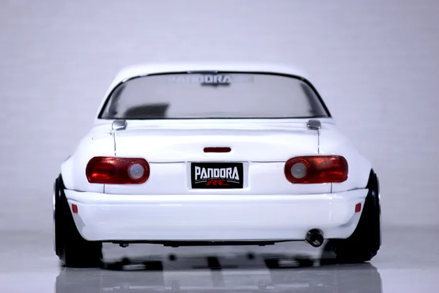 Rear view of a white Pandora RC Mazda Eunos Roadster body shell featuring tail lights, exhaust tip, and Pandora RC branding.