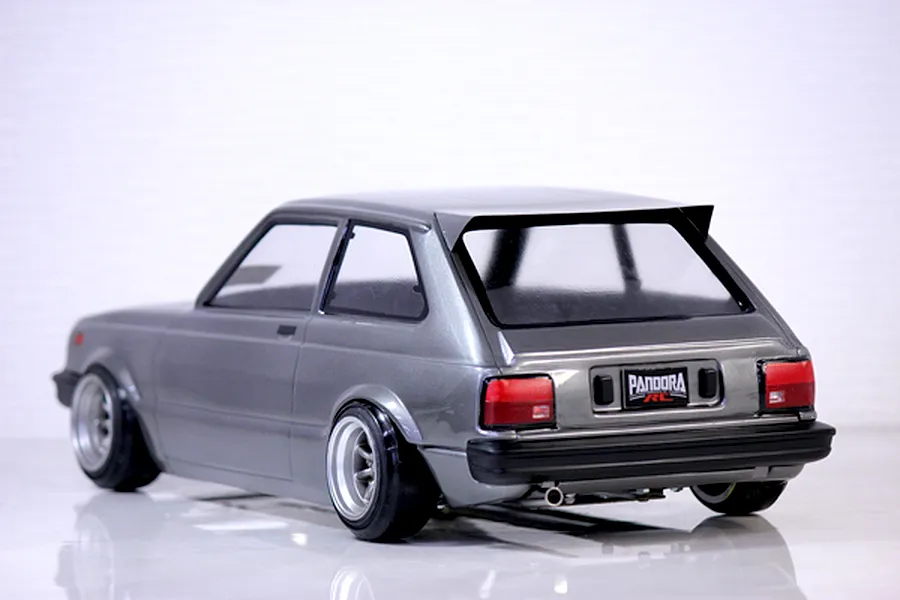 Rear three-quarter view of a grey Pandora RC Toyota Starlet KP61 body shell mounted on an RC chassis with deep dish wheels.