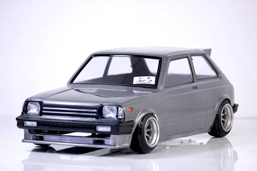 A grey Pandora RC Toyota Starlet KP61 late model body shell mounted on an RC chassis with custom wheels against a white background.