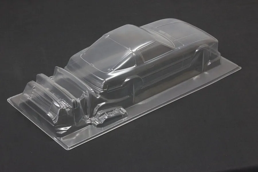 Unpainted clear polycarbonate RC car body shell for a Mazda Savanna RX-7 on a dark surface.