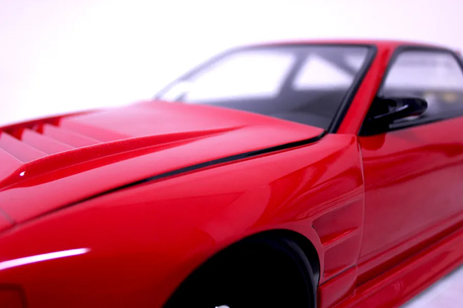 Close-up of the red painted front fender and vented hood of a Pandora RC 180SX body shell.