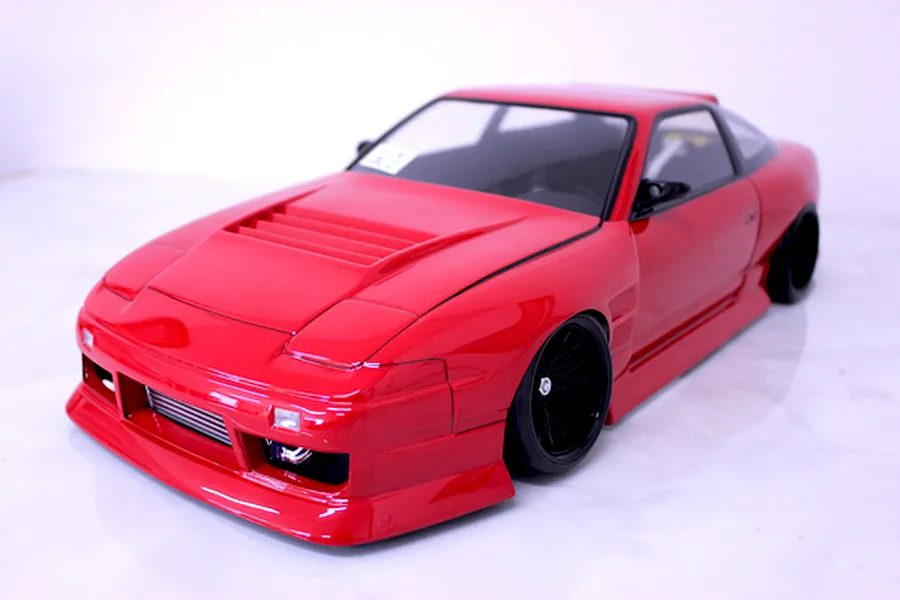 Front three-quarter view of a red Pandora RC 180SX drift car body shell mounted on a chassis with black wheels.