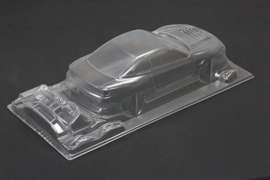 Unpainted clear polycarbonate RC drift car body shell viewed from the rear three-quarter angle against a dark background.