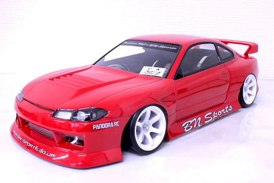 Red Pandora RC S15 Silvia BN Sports body shell mounted on an RC chassis with white wheels against a white background.