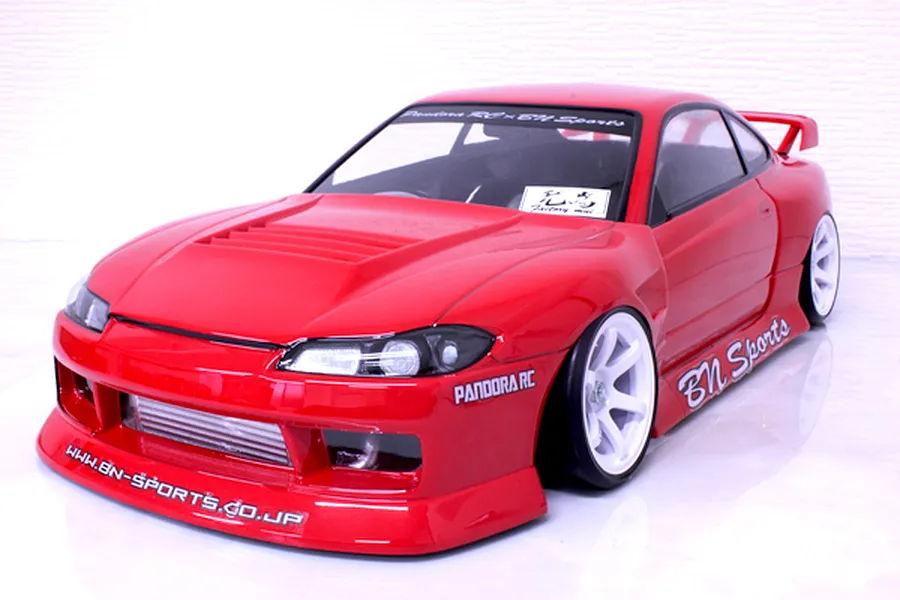 Red Pandora RC S15 Silvia BN Sports body shell on a drift chassis with white wheels against a white background.