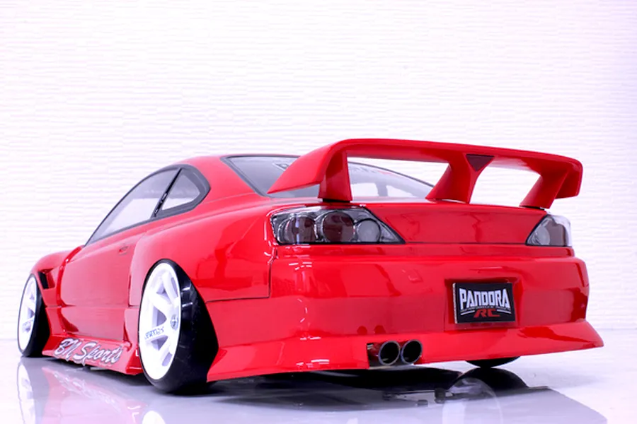 Rear view of a red RC drift car body shell, model S15 Silvia with BN Sports kit, on a white surface.