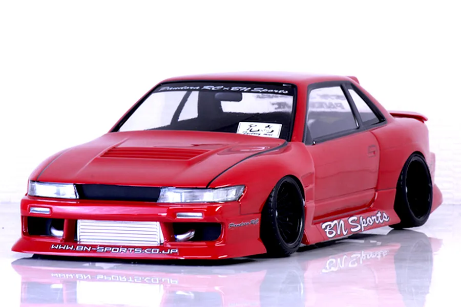 Red Pandora RC S13 Silvia drift body shell mounted on an RC chassis with BN Sports decals against a white background.