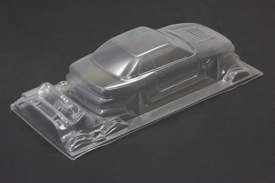 Unpainted clear polycarbonate RC drift car body shell viewed from rear three-quarters on a dark background.