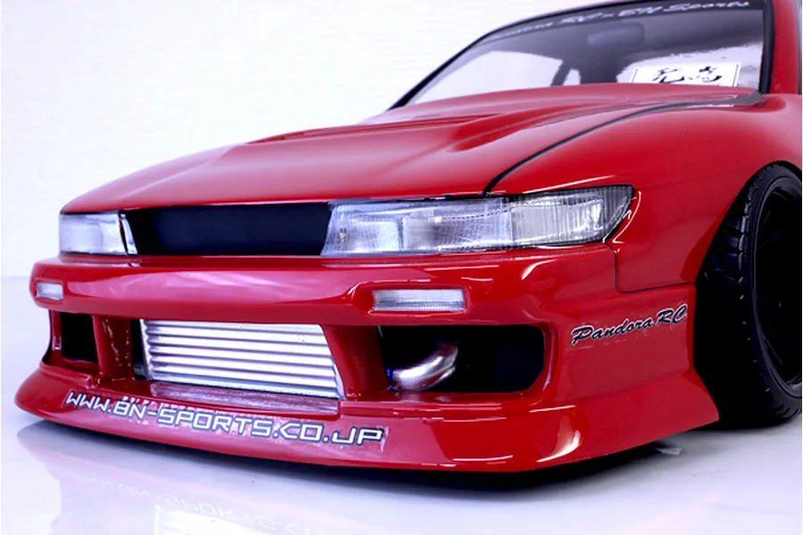 Close-up front angle of a red Pandora RC S13 Silvia drift car body shell featuring BN Sports styling, front intercooler, and decal details.