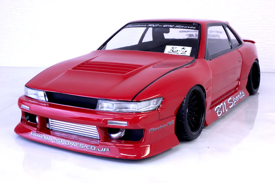 Red Pandora RC S13 Silvia BN Sports drift body shell mounted on an RC chassis with custom wide body kit and black wheels.