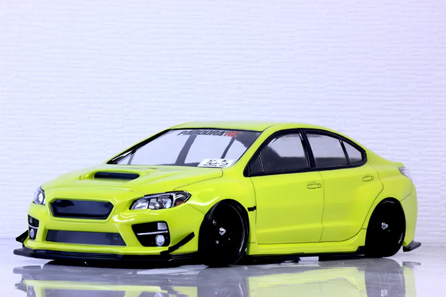 Bright lime green Subaru WRX STI RC drift car body shell mounted on a chassis with black multi-spoke wheels against a white wall.