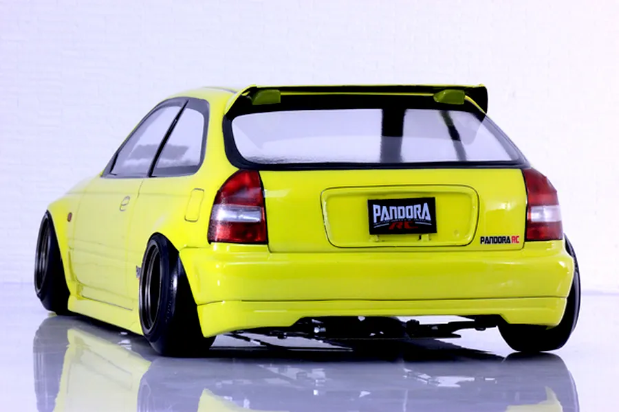 Rear three-quarter view of a yellow RC Honda Civic EK9 body shell with custom wheels and a Pandora RC license plate against a white background.