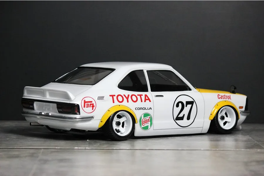 Rear-three-quarter view of a painted white Toyota Corolla Levin TE27 RC body shell with racing decals and number 27.