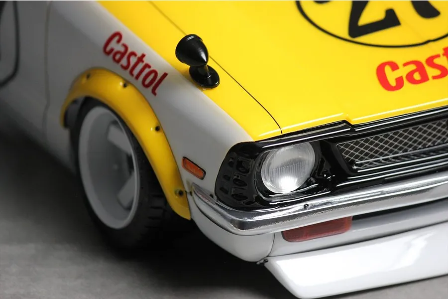 Close-up of the front corner of a painted RC car body, showing the headlight, fender flare, mirror, and Castrol decals.