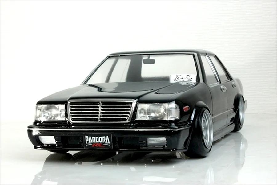 Front three-quarter view of a black Pandora RC Y31 Cedric sedan body shell with custom wheels against a white background.