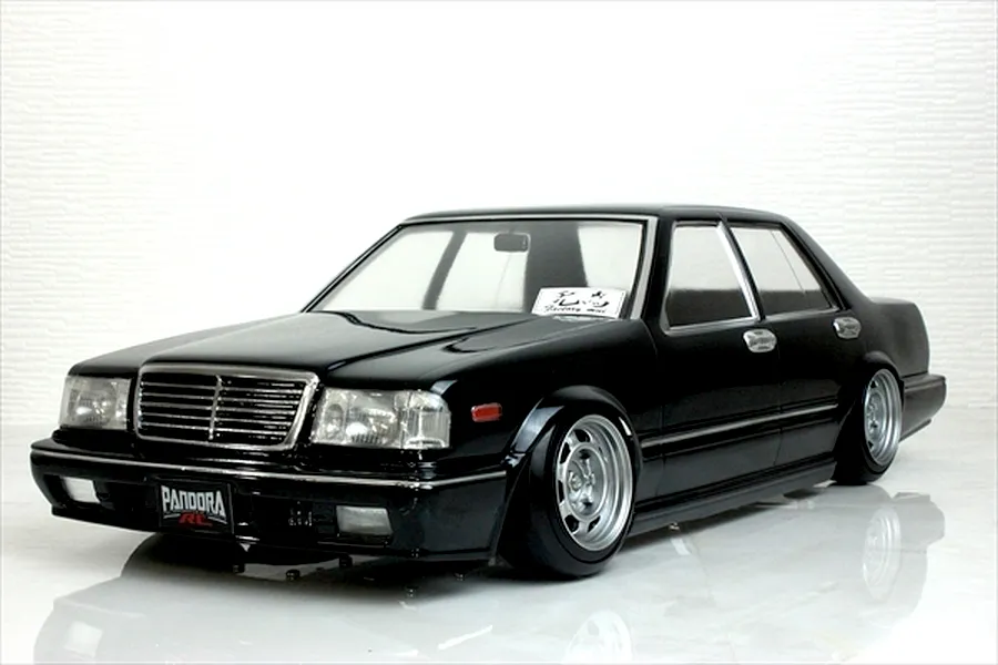 A painted black Pandora RC Y31 Cedric sedan drift body shell mounted on an RC chassis against a white background.