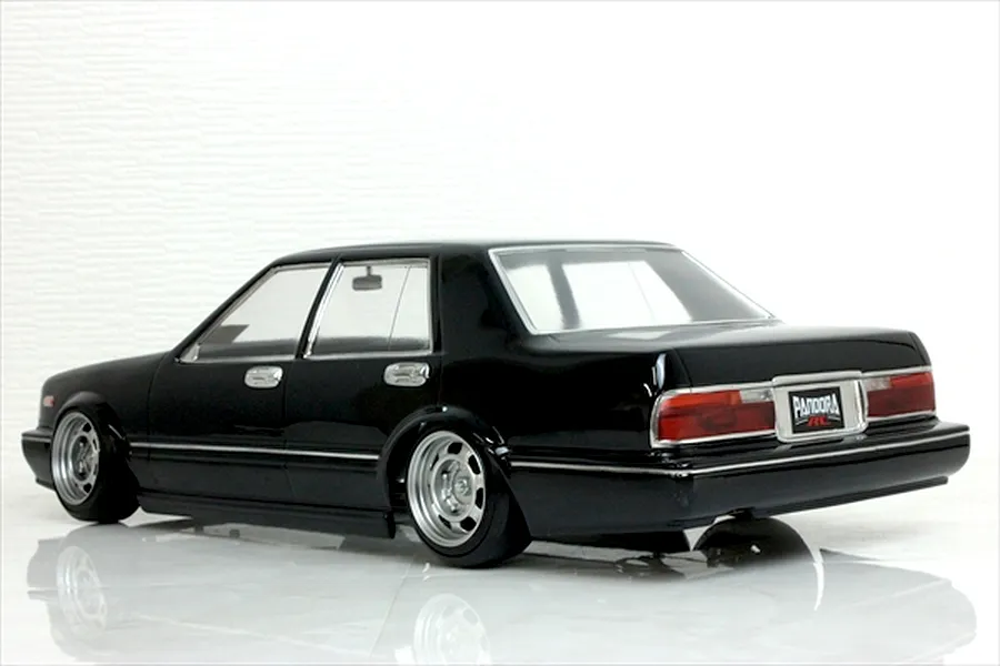 Rear three-quarter view of a black Y31 Cedric sedan RC drift car body shell on a glossy white surface.