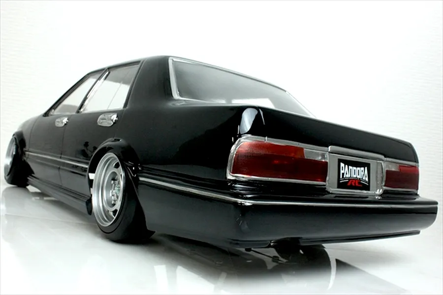 Rear quarter angle view of a black Pandora RC Y31 Cedric Sedan drift body shell with chrome trim and custom deep-dish wheels.