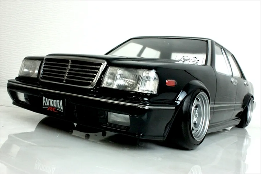 Low angle studio shot of a black Pandora RC Y31 Cedric Sedan body shell mounted on an RC chassis with deep dish wheels.