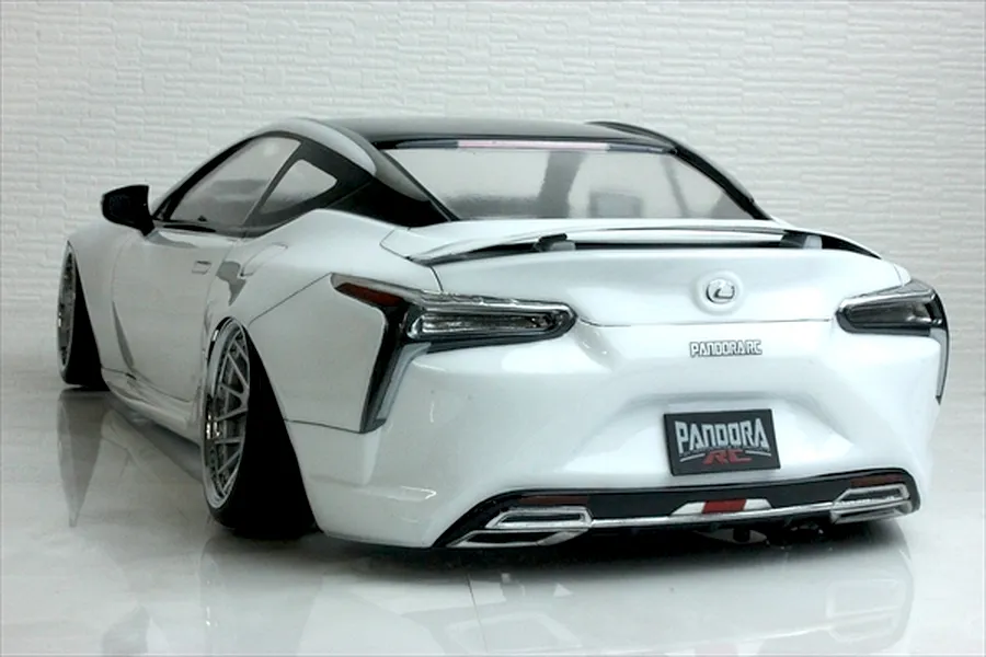 Rear three-quarter view of a painted white Pandora RC Lexus LC drift body shell on a reflective surface