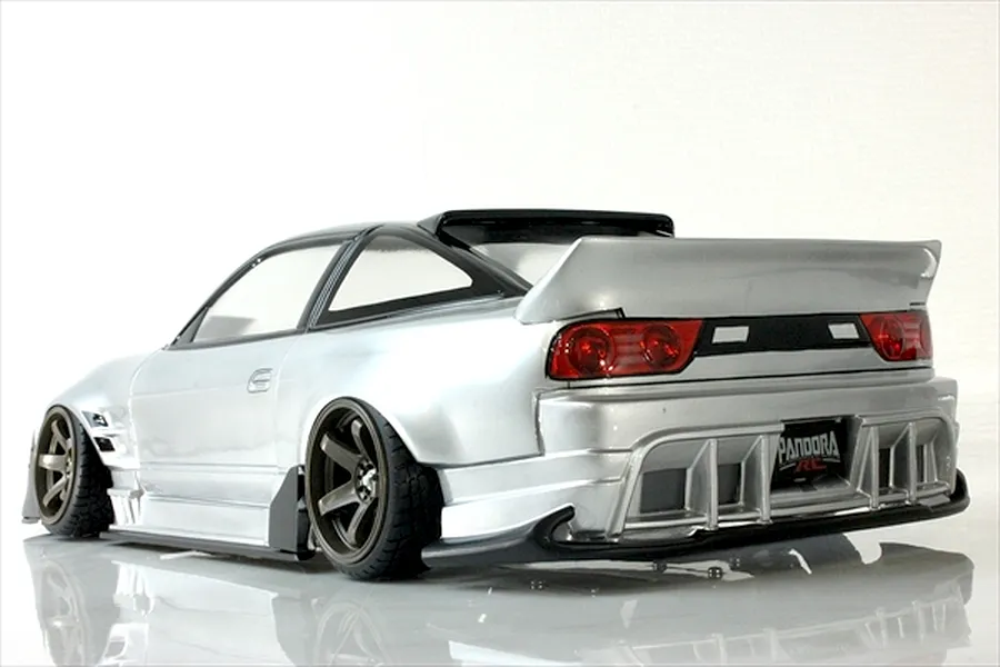 Rear-angle studio shot of a silver Pandora RC drift car body with custom aero, spoiler, and bronze wheels against a white background.