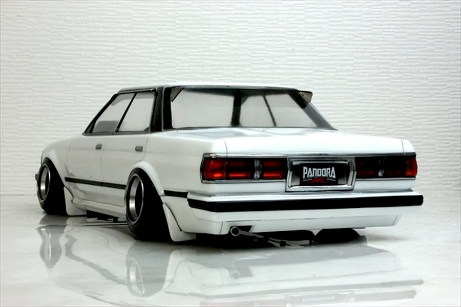 Rear three-quarter view of a white Pandora RC Toyota Mark 2 GX71 drift body shell on a reflective surface.