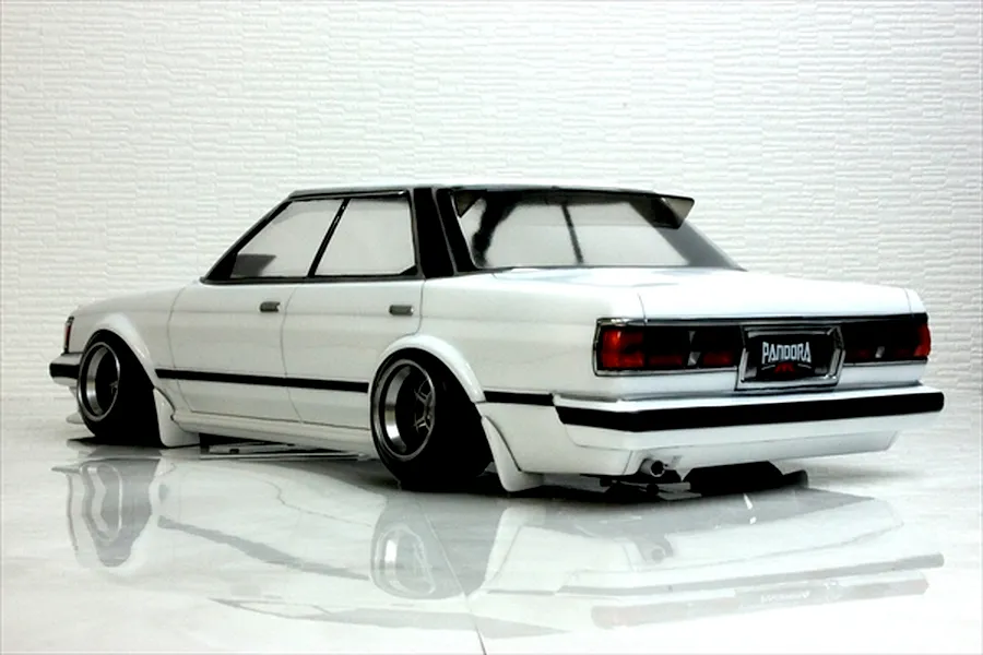 Rear three-quarter view of a white RC drift car body shell representing a Toyota Mark 2 GX71 on a reflective white studio surface.