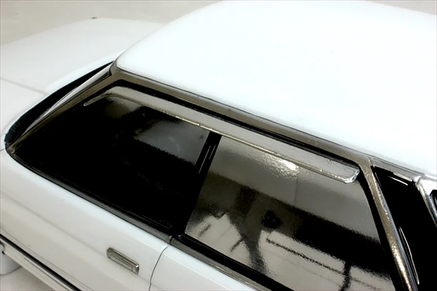 Close-up view of the side windows, roof, and door handle on a white RC car body shell.