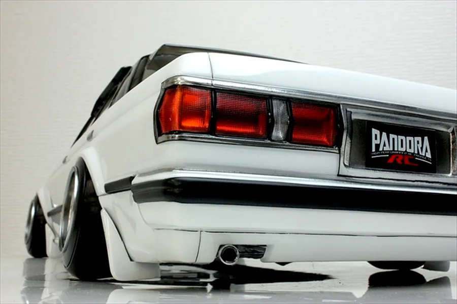 Rear low angle view of a white Pandora RC Toyota Mark 2 GX71 body shell featuring realistic taillights, chrome trim, and wide stance drift wheels.