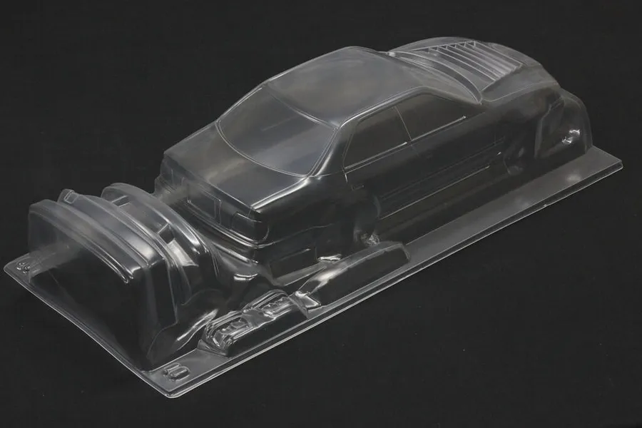 Unpainted clear polycarbonate RC car body shell for Toyota Chaser JZX100 on a dark background.