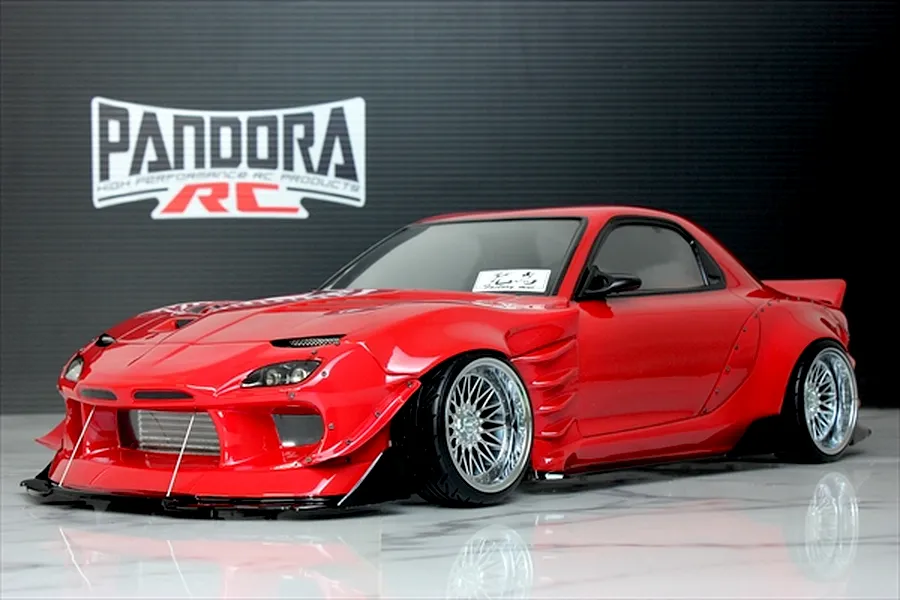 Red Pandora RC Mazda RX-7 FD3S BN Sports drift car body shell on a reflective surface with a branded backdrop.