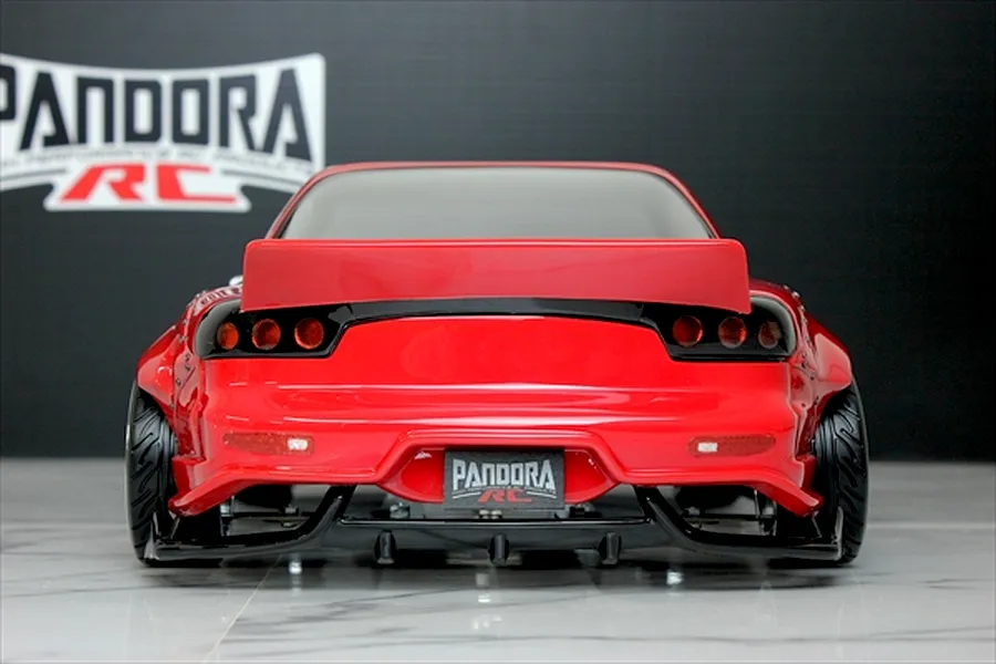 Rear view of a painted red Pandora RC Mazda RX-7 FD3S RC drift car body with a rear spoiler and Pandora RC logo in the background.