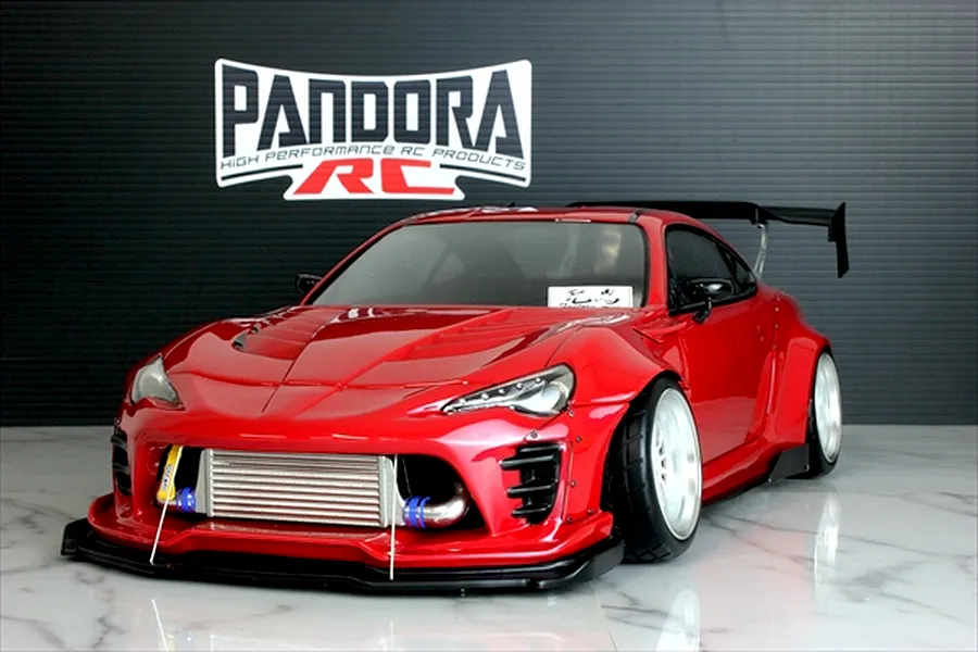 Red Pandora RC Toyota 86 body shell with widebody kit, front intercooler, and large rear wing.
