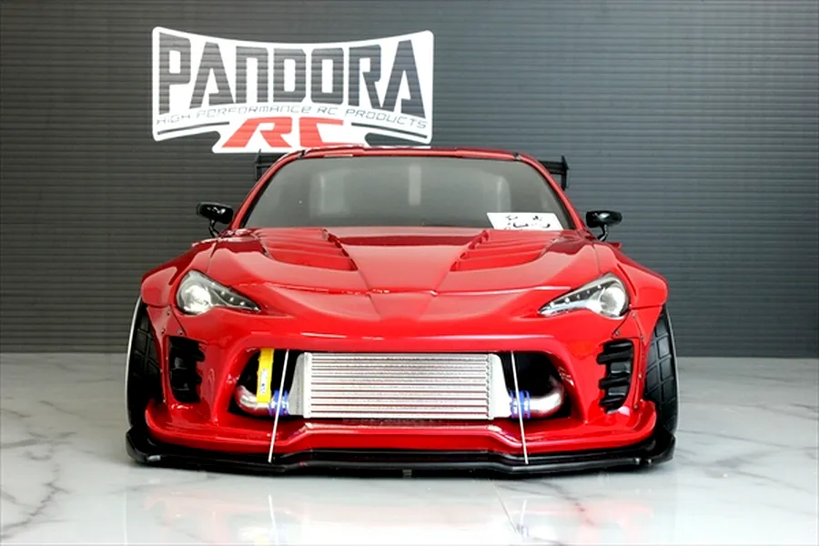 Front view of a red RC drift car body styled as a Toyota 86 with BN Sports kit, featuring an intercooler and Pandora RC logo in background.